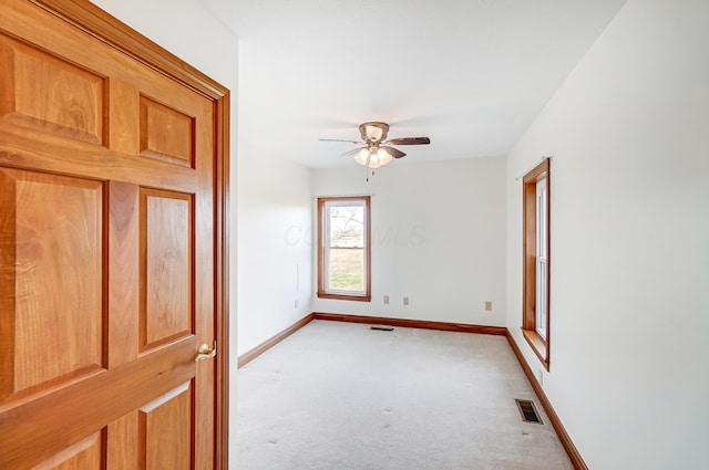 carpeted spare room featuring ceiling fan