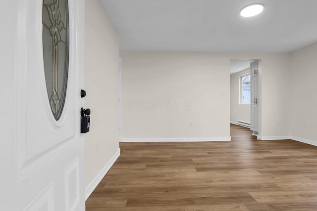 interior space featuring a baseboard radiator and hardwood / wood-style flooring