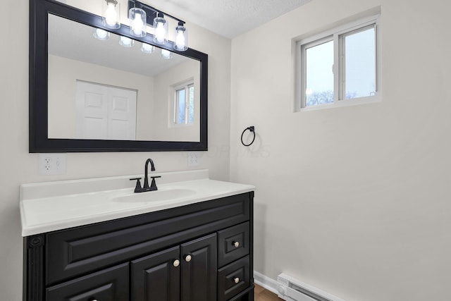 bathroom with vanity, a baseboard radiator, and a textured ceiling