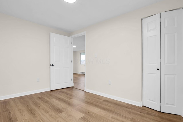 unfurnished bedroom with light hardwood / wood-style flooring and a closet