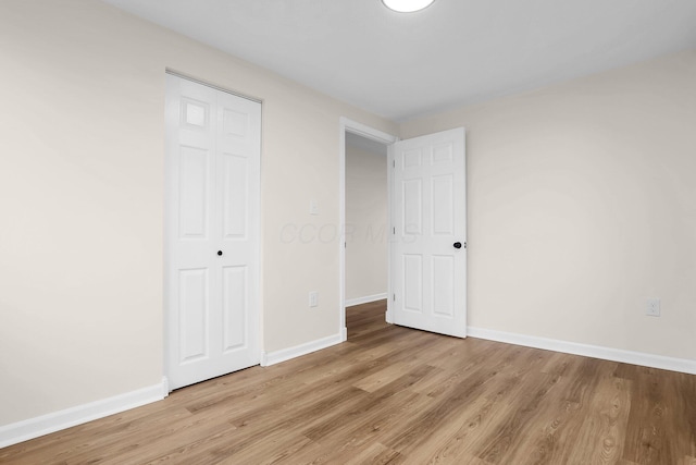 unfurnished bedroom with light hardwood / wood-style floors and a closet