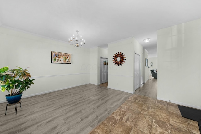 spare room featuring a chandelier, hardwood / wood-style floors, and ornamental molding