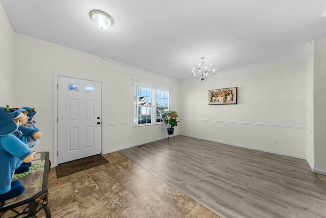 foyer entrance with ornamental molding, wood-type flooring, and a notable chandelier