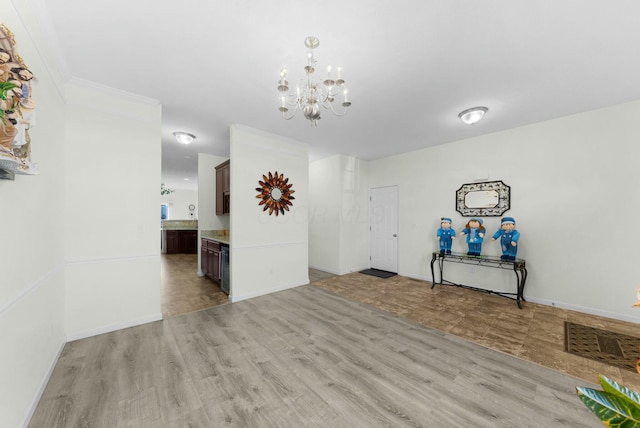 interior space with ornamental molding, light hardwood / wood-style flooring, and a notable chandelier