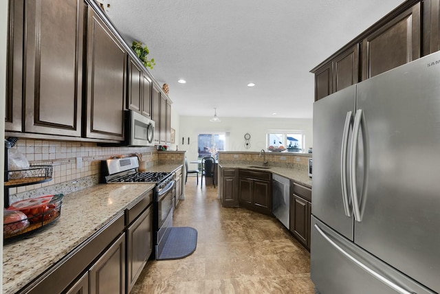 kitchen with dark brown cabinetry, sink, appliances with stainless steel finishes, and tasteful backsplash