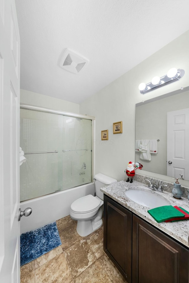 full bathroom with combined bath / shower with glass door, vanity, and toilet