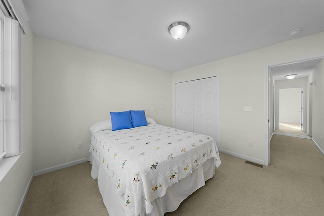 bedroom with light carpet and a closet