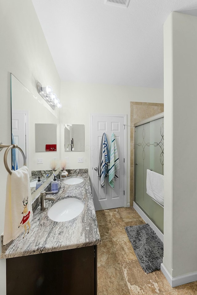 bathroom with vanity and a shower with shower door