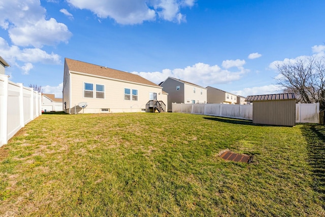 rear view of house with a yard and a storage shed