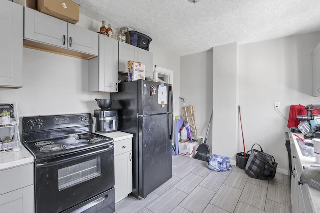 kitchen featuring white cabinets, black appliances, and a textured ceiling