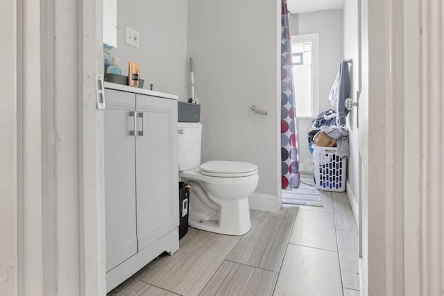 bathroom with vanity, toilet, and wood-type flooring