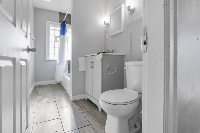 full bathroom with shower / tub combo with curtain, vanity, and toilet