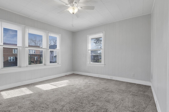 carpeted spare room featuring ceiling fan