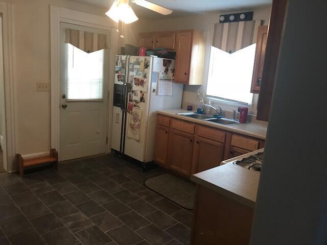 kitchen featuring plenty of natural light, gas cooktop, white refrigerator with ice dispenser, and sink