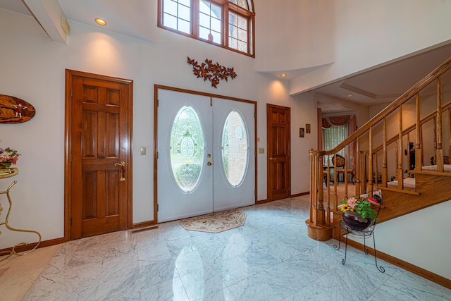 foyer featuring french doors and a towering ceiling