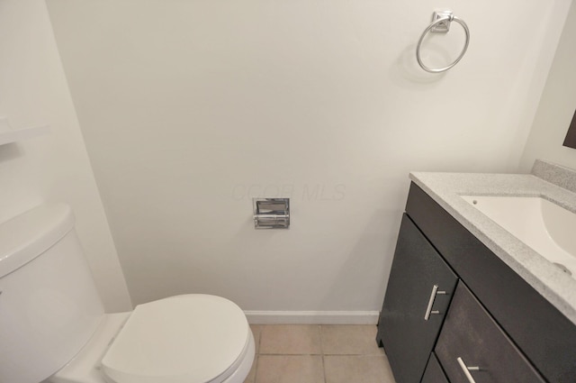 bathroom with tile patterned flooring, vanity, and toilet