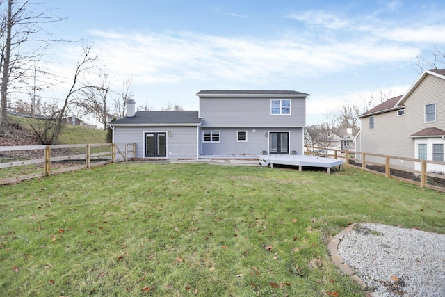 back of house with a lawn and a deck