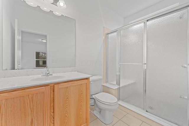 bathroom with tile patterned flooring, toilet, an enclosed shower, and vanity