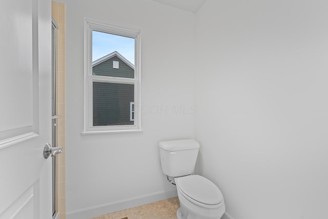 bathroom with tile patterned floors, toilet, and walk in shower