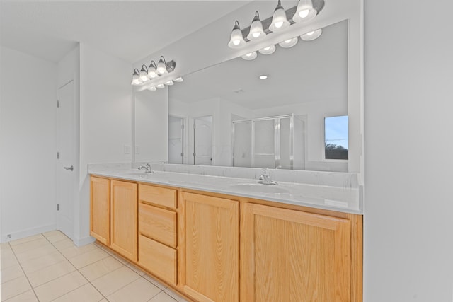 bathroom with a shower with door, vanity, and tile patterned flooring