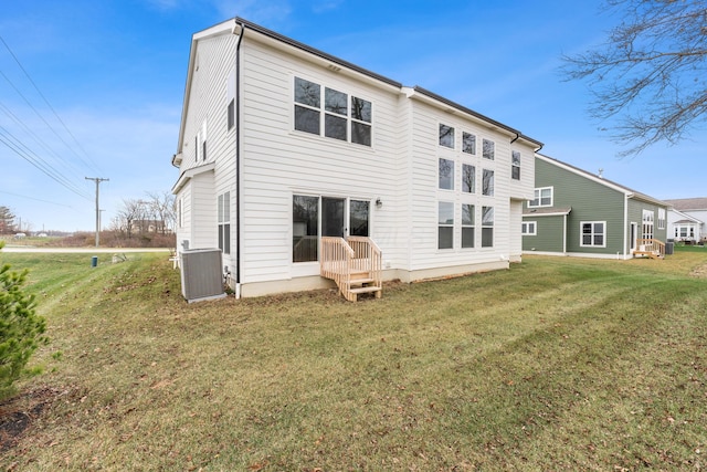 rear view of property featuring a lawn and central AC unit