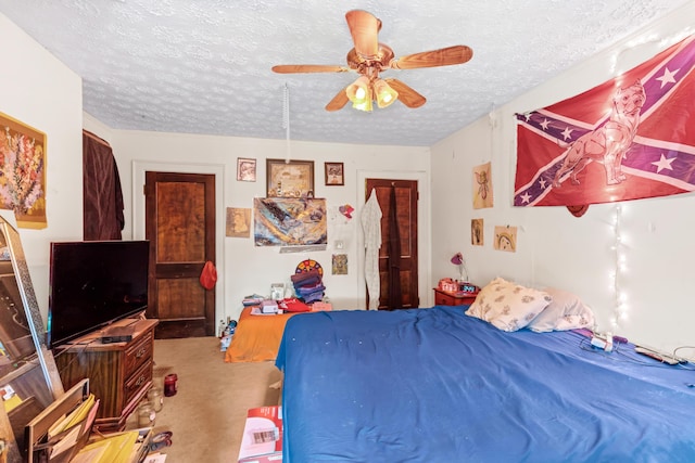 bedroom featuring ceiling fan, carpet, and a textured ceiling