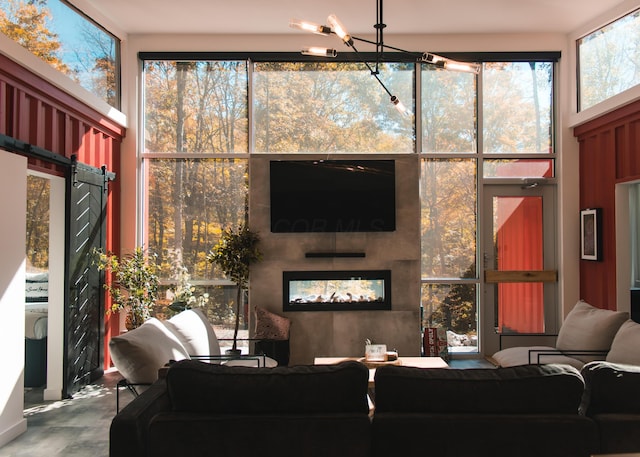 living room with an inviting chandelier and concrete floors