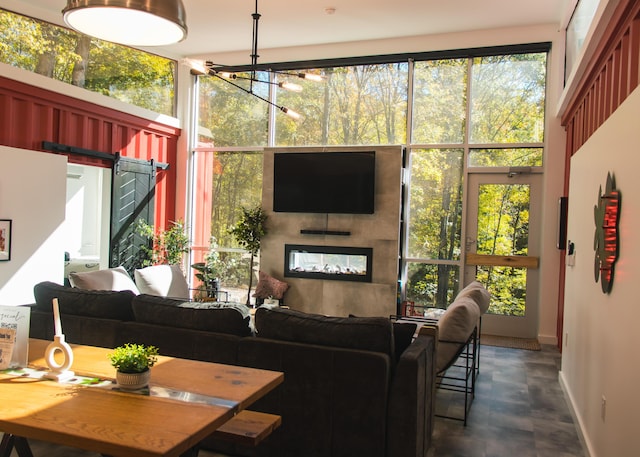 living room featuring a barn door, an inviting chandelier, a wealth of natural light, and concrete floors