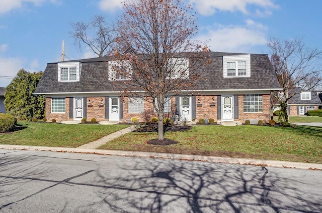 cape cod house featuring a front lawn