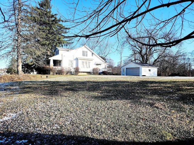 view of side of property with a lawn, an outdoor structure, and a garage