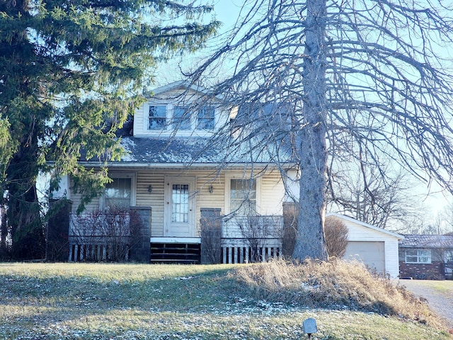 view of front of property featuring a porch, a garage, and an outbuilding