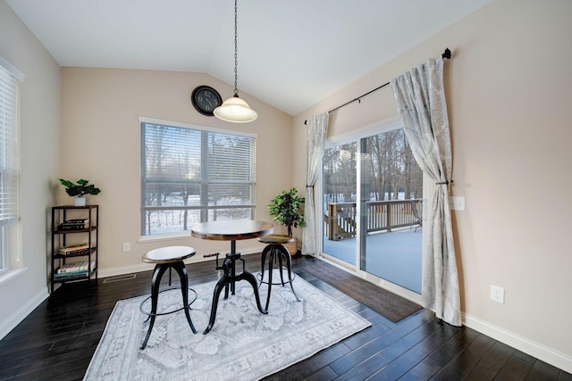 dining space featuring lofted ceiling and dark hardwood / wood-style floors