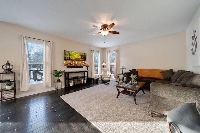 living room with dark wood-type flooring and ceiling fan