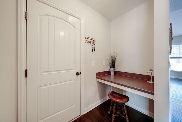 office space with hardwood / wood-style flooring, built in desk, and a textured ceiling