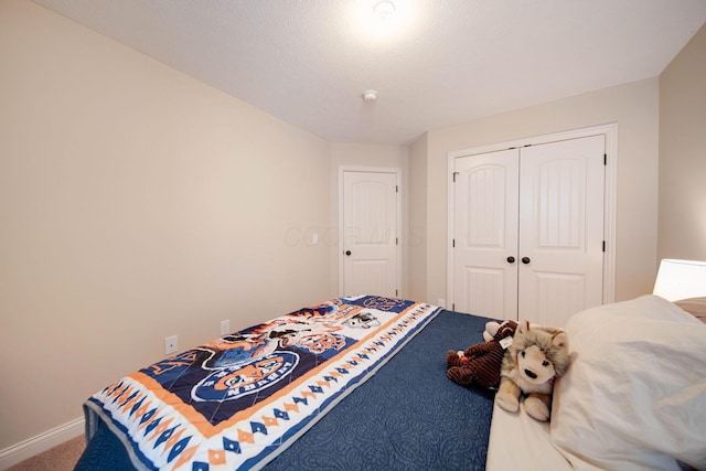 carpeted bedroom with a closet and a textured ceiling