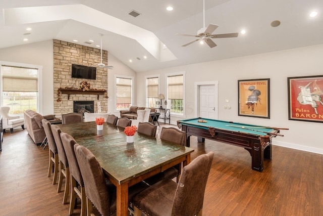 recreation room featuring lofted ceiling, a stone fireplace, dark hardwood / wood-style floors, and ceiling fan