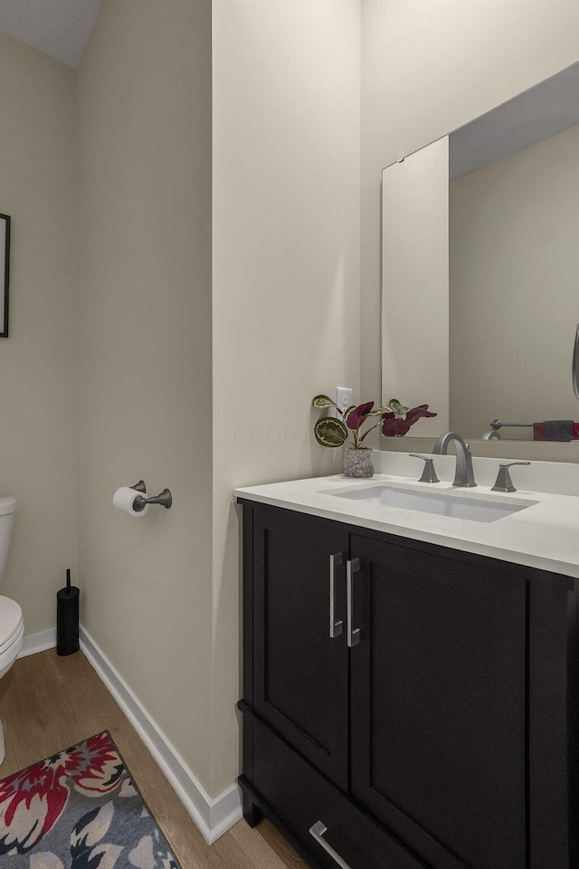 bathroom featuring hardwood / wood-style floors, vanity, and toilet