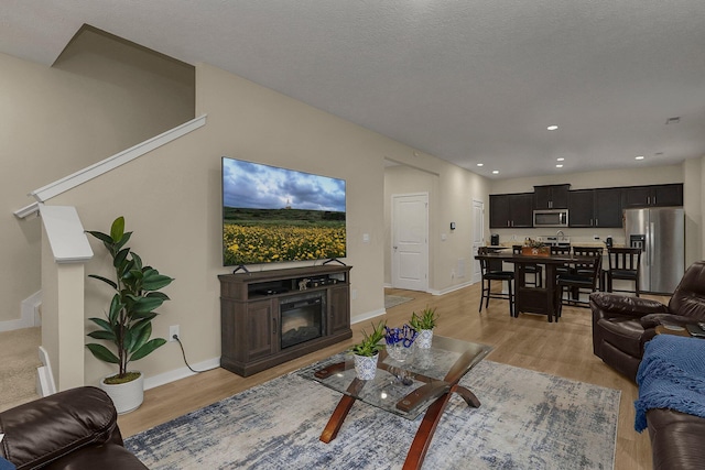 living room with light hardwood / wood-style floors and a textured ceiling