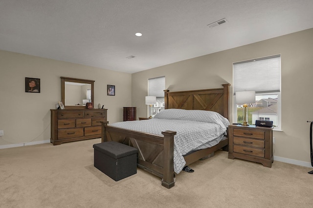 bedroom featuring light carpet and a textured ceiling