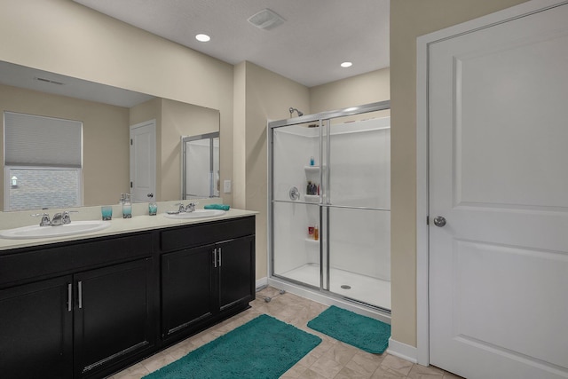 bathroom with a shower with door and vanity