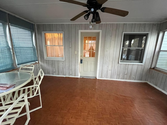 unfurnished sunroom featuring ceiling fan