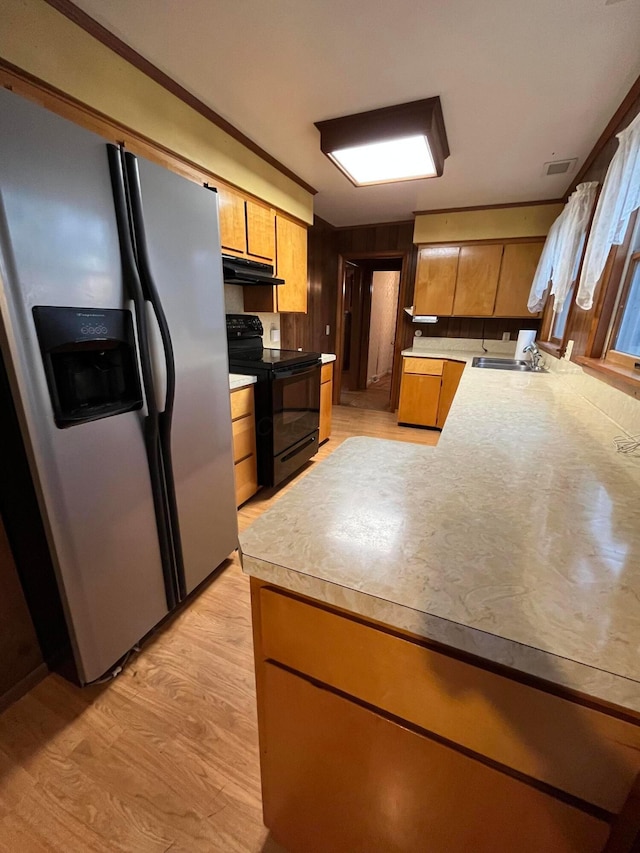 kitchen featuring black electric range, stainless steel fridge, light hardwood / wood-style floors, and sink