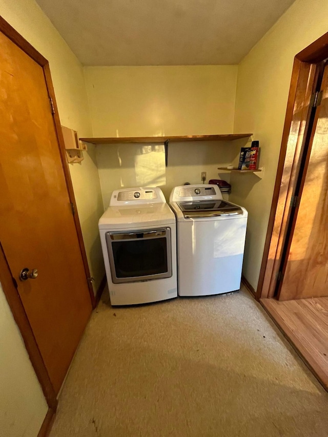 clothes washing area with separate washer and dryer and light colored carpet