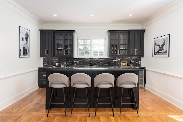 kitchen with a kitchen island, a breakfast bar area, backsplash, and light hardwood / wood-style floors