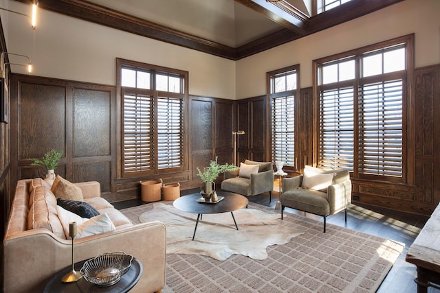 living room with crown molding, a towering ceiling, and plenty of natural light