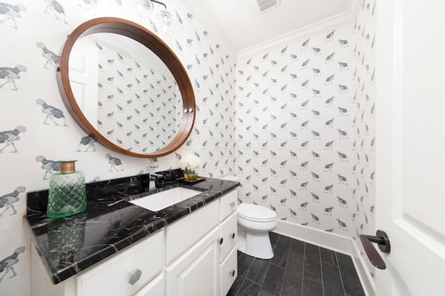 bathroom with ornamental molding, toilet, and vanity