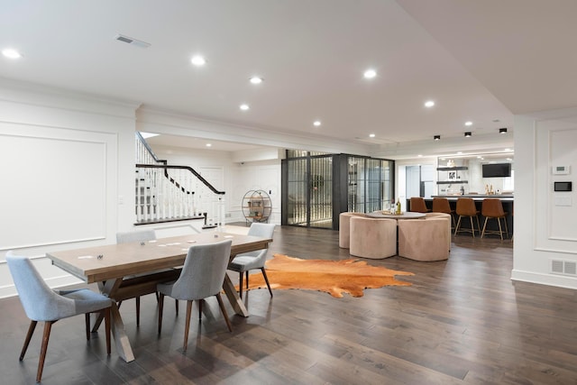 dining room with dark hardwood / wood-style flooring and ornamental molding