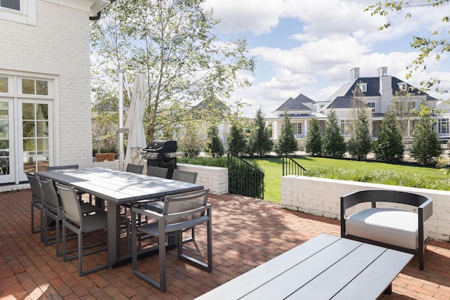 wooden terrace featuring a grill, a yard, and a patio area