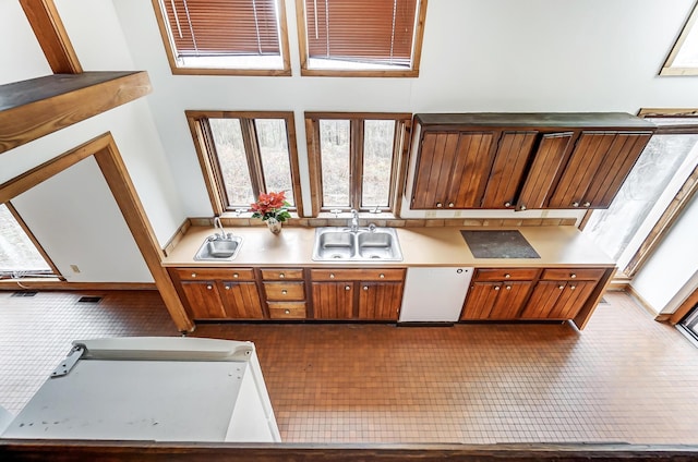 kitchen featuring dishwasher, sink, and tile patterned flooring