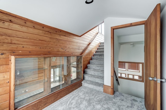 additional living space featuring wooden walls, carpet, and lofted ceiling